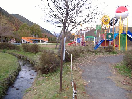 松尾峡 ほたる童謡公園の金属遊具のすぐ横にホタル生息水路が流れる写真。